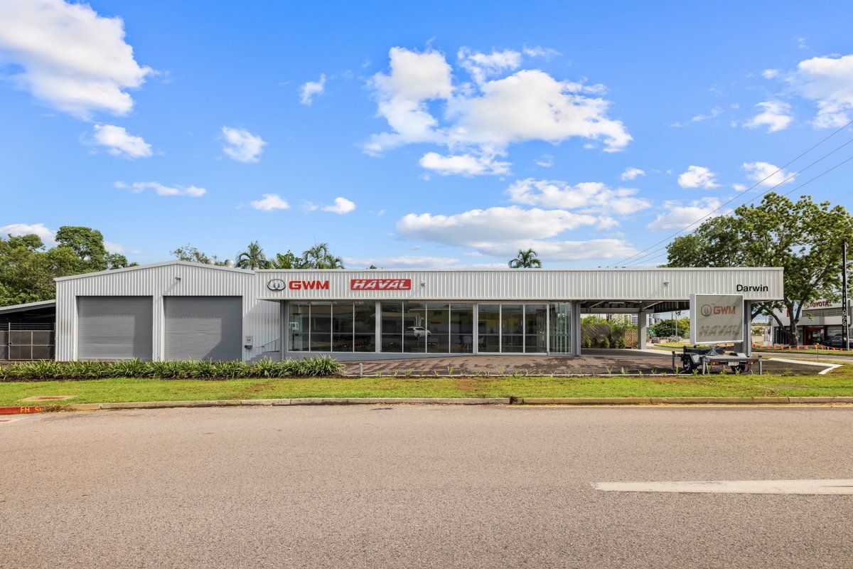 Empty car dealership building with blue sky in background