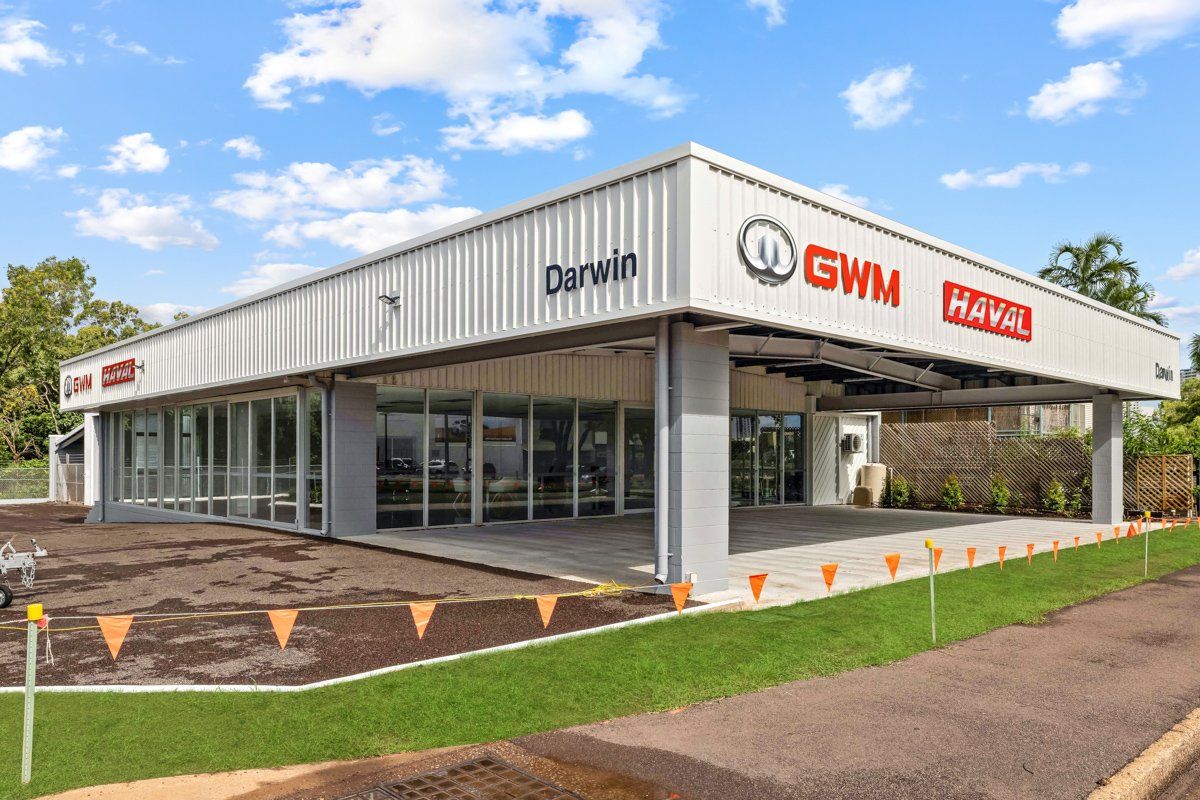 GWM Haval car dealership in Darwin, Australia. White building with glass front, green lawn, blue sky.