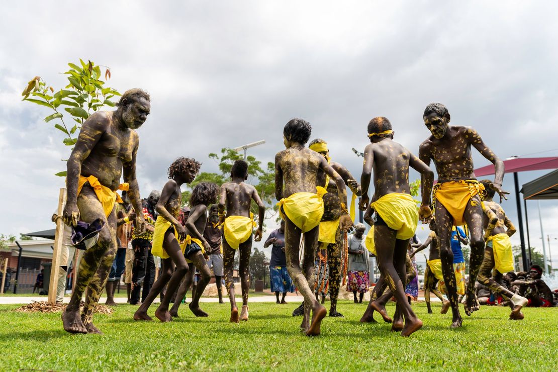 Indigenous community members in traditional dress performing ceremony