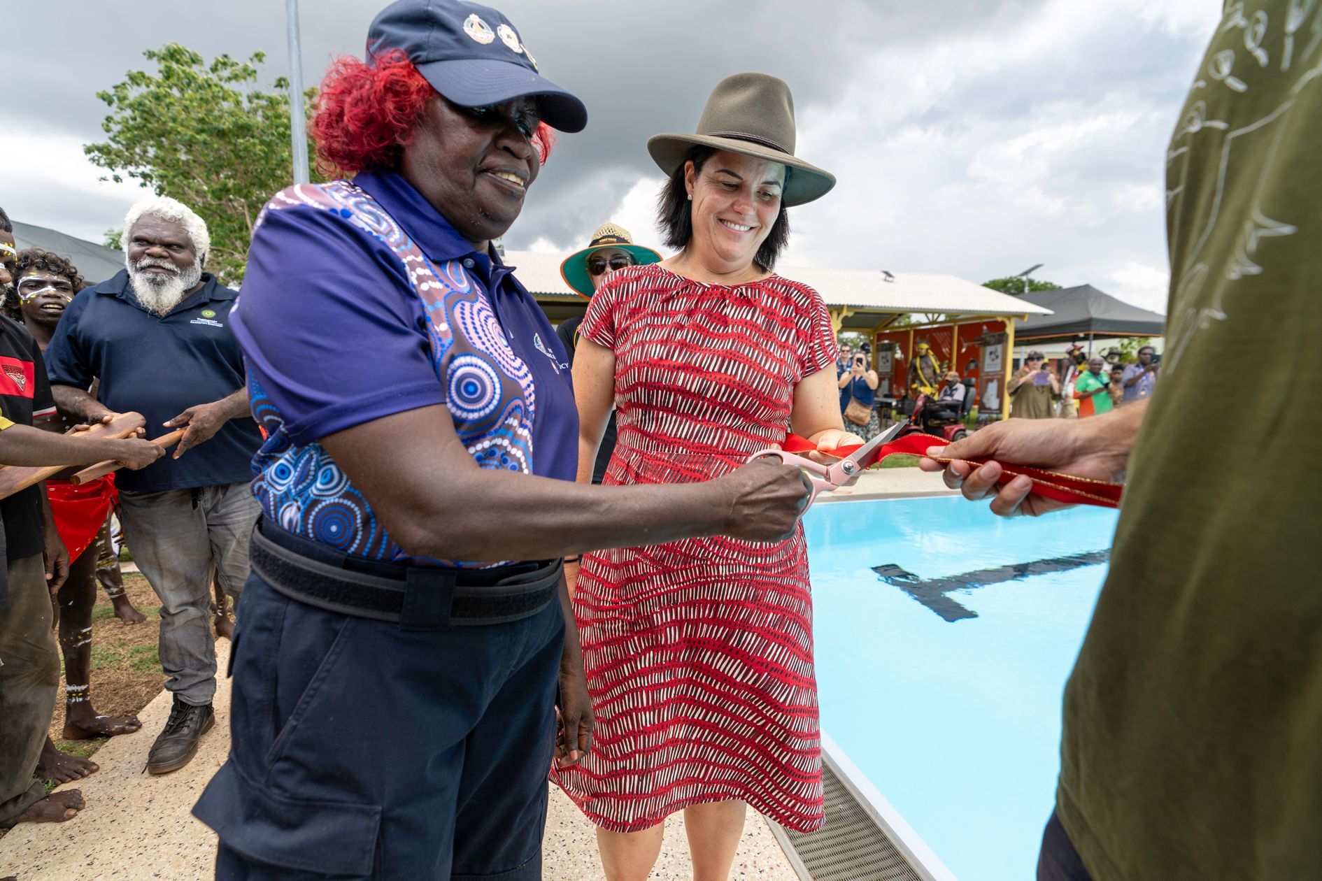 Indigenous community member cutting red ribbon at Wadeye Community Pool opening