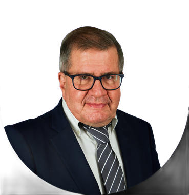 Man in glasses and suit, smiling.