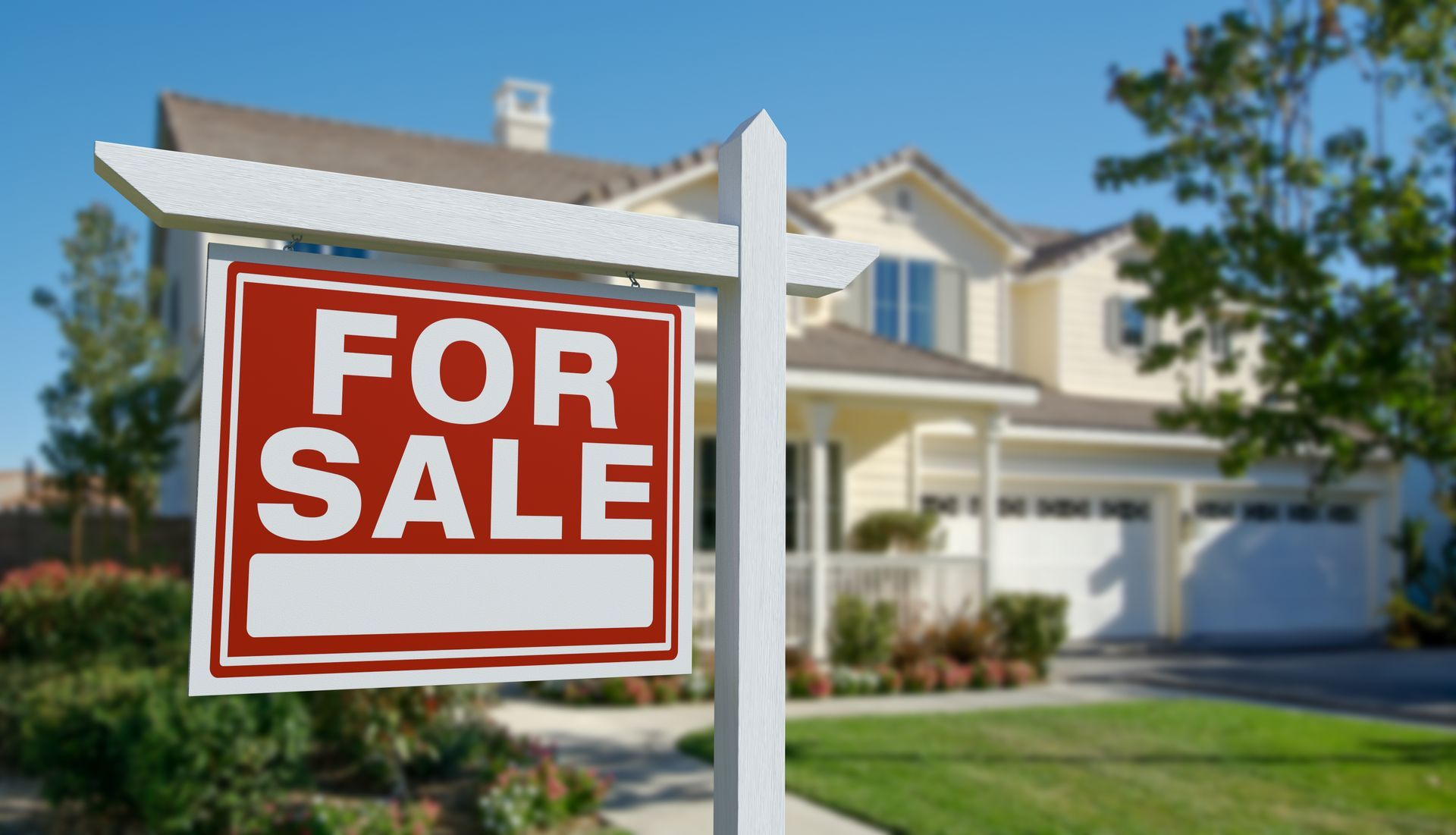 A for sale sign is in front of a house.