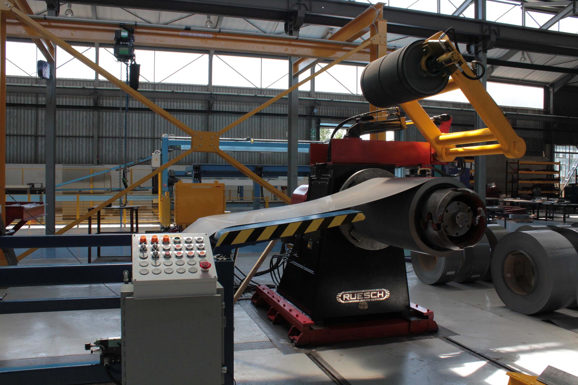 a machine is sitting in a factory with a conveyor belt attached to it .