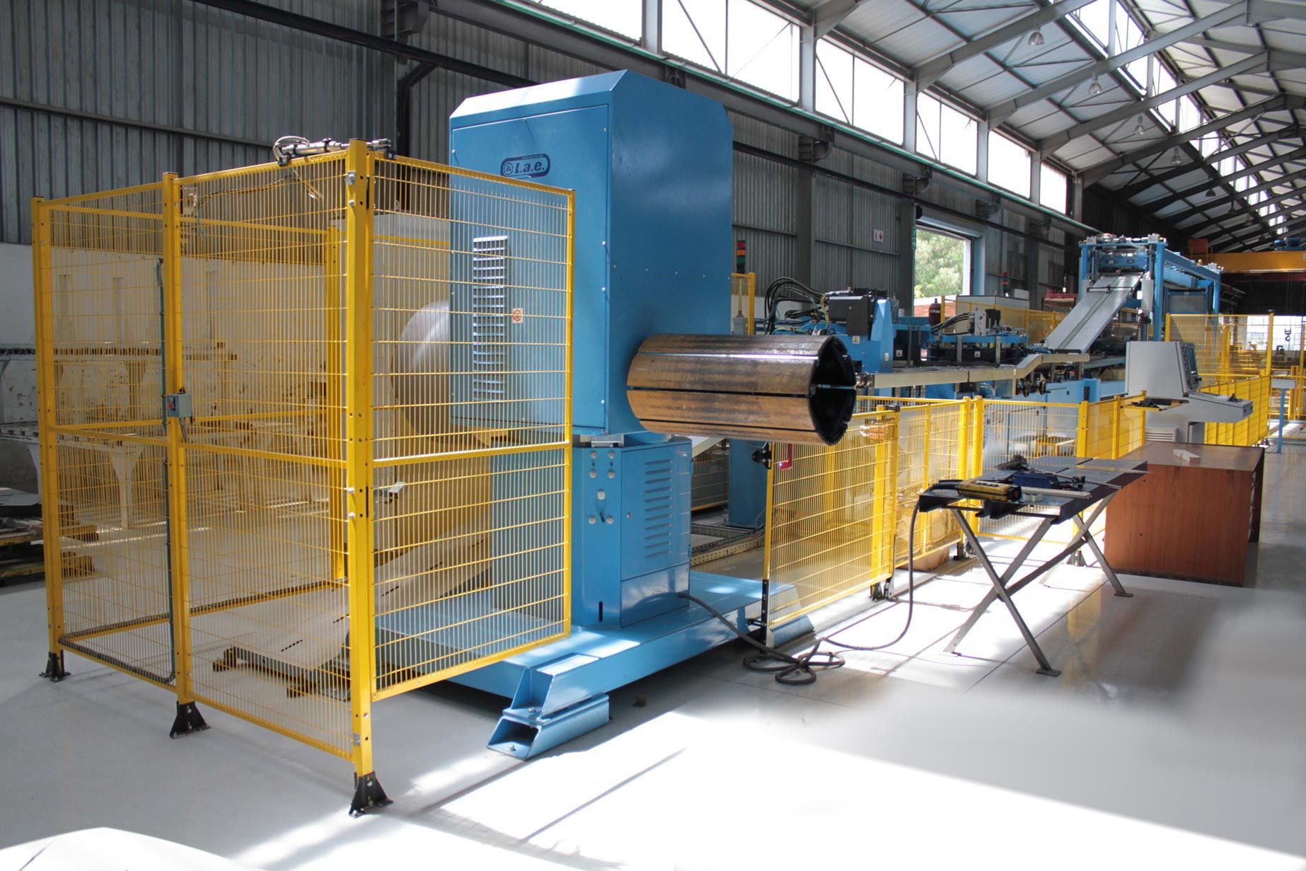 a machine is sitting in a warehouse with a yellow fence around it .