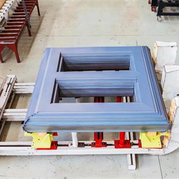 a large piece of metal is sitting on top of a table in a factory .