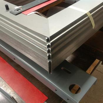 a metal frame is sitting on a table next to a ruler that says ' aluminum ' on it