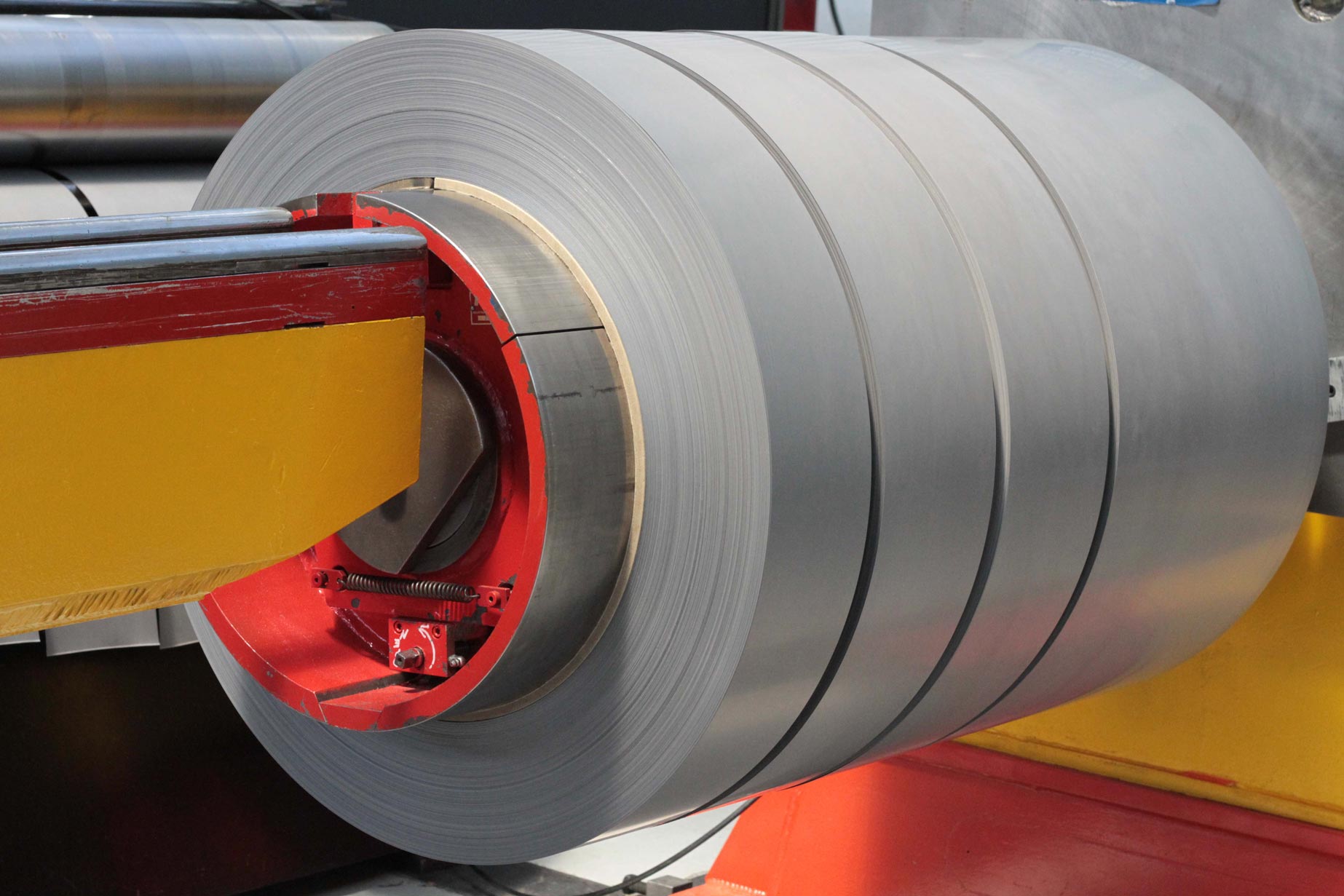 a large roll of metal is being cut by a machine