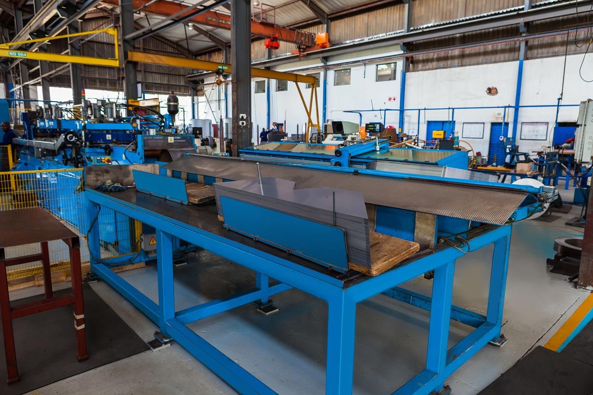 a factory with a lot of blue tables and machinery .
