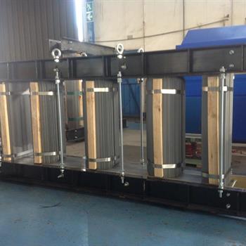 a large metal structure with wooden pillars is sitting in a room .