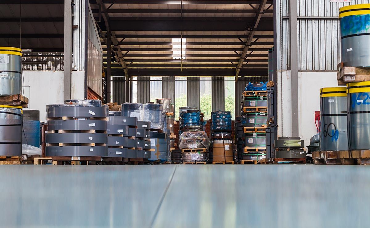 a large warehouse filled with lots of barrels and containers .