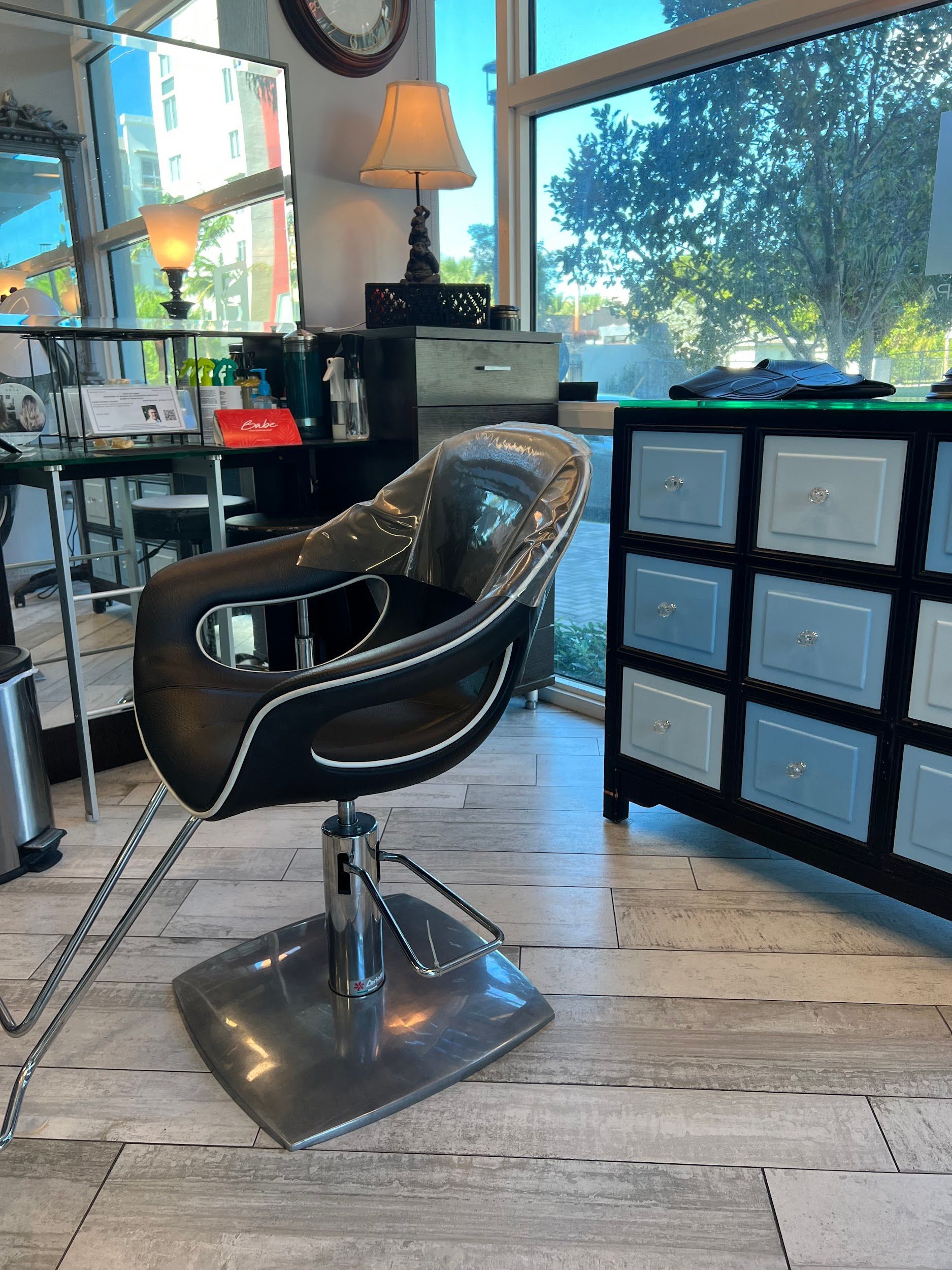 Salon chair in a stylish salon with a view and a cabinet with drawers.