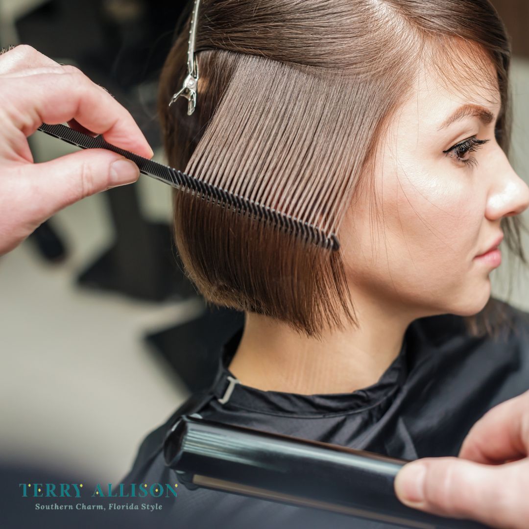 Woman getting a haircut at a salon. Hairdresser combs and straightens brown hair.