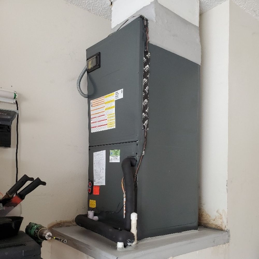 an air conditioner is sitting on a shelf in a room .