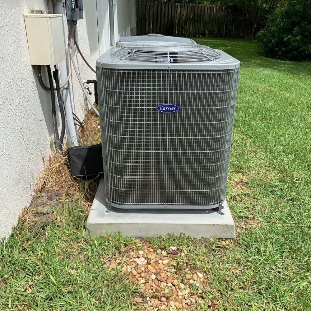a large air conditioner is sitting in the grass next to a house .