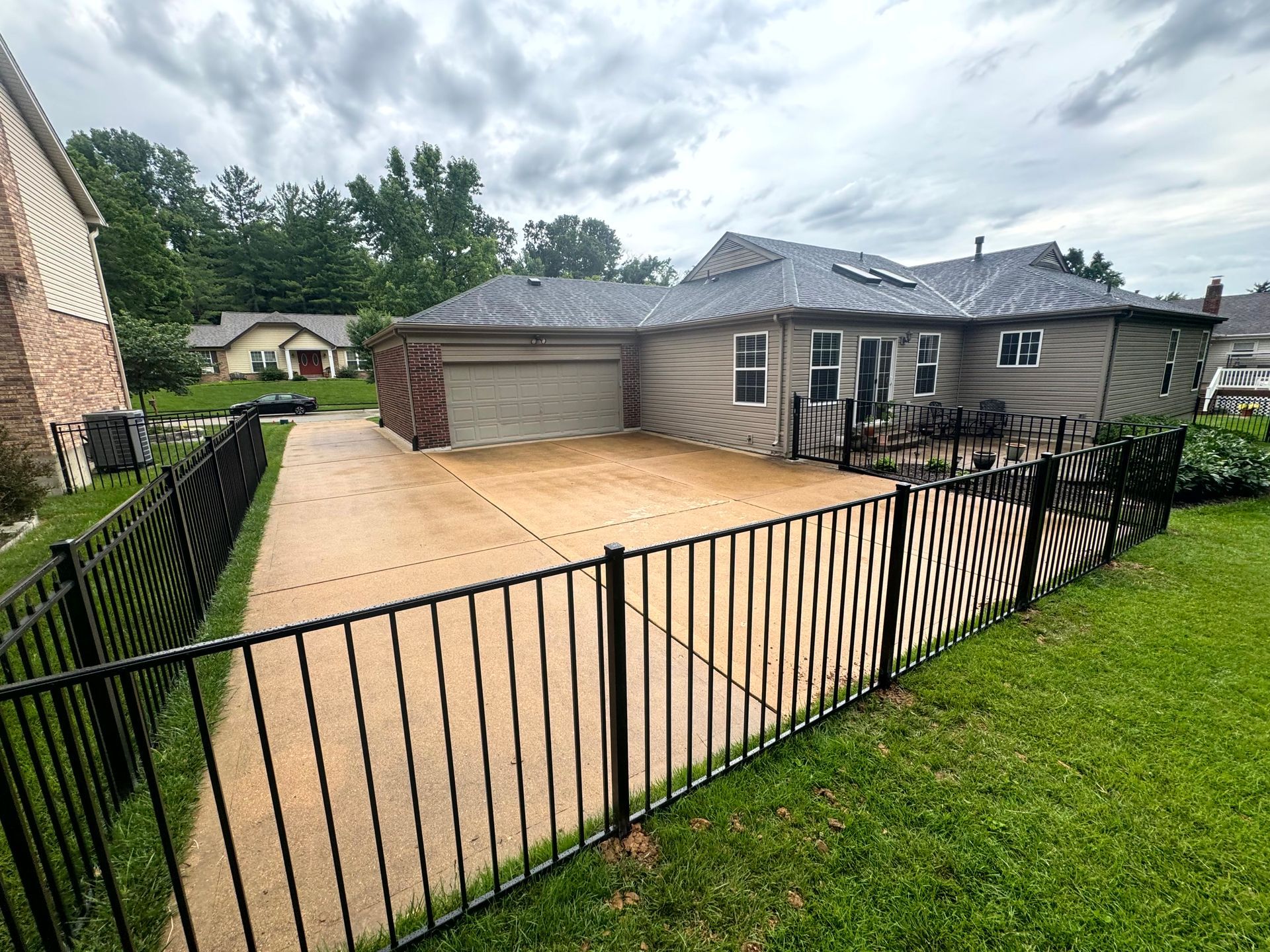 Brick house with a ramp leading to the entrance, black railings, and white vertical accents on the sides.