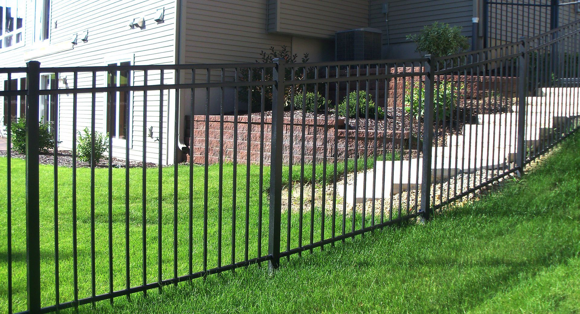 Black aluminum fence installation along backyard walkway – durable, low-maintenance ornamental fencing in St. Louis MO.