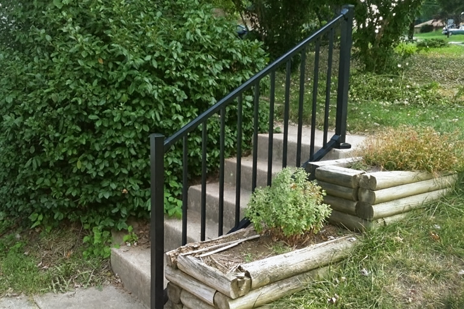 Black aluminum handrail installed on concrete garden steps – durable railing for outdoor safety in St. Louis MO.