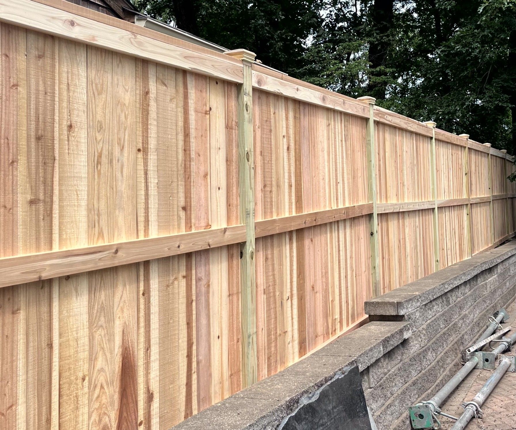 Cedar wood fence installation in progress showing posts and fence panels