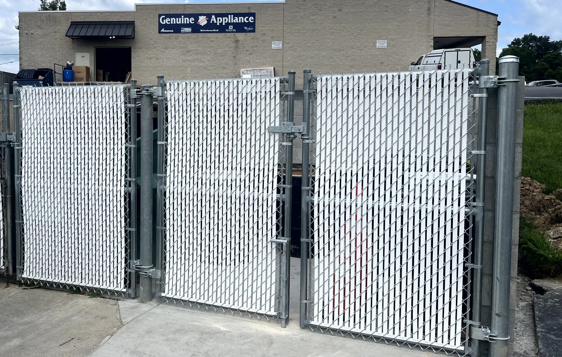 Chain link dumpster enclosure with locking gates for commercial property