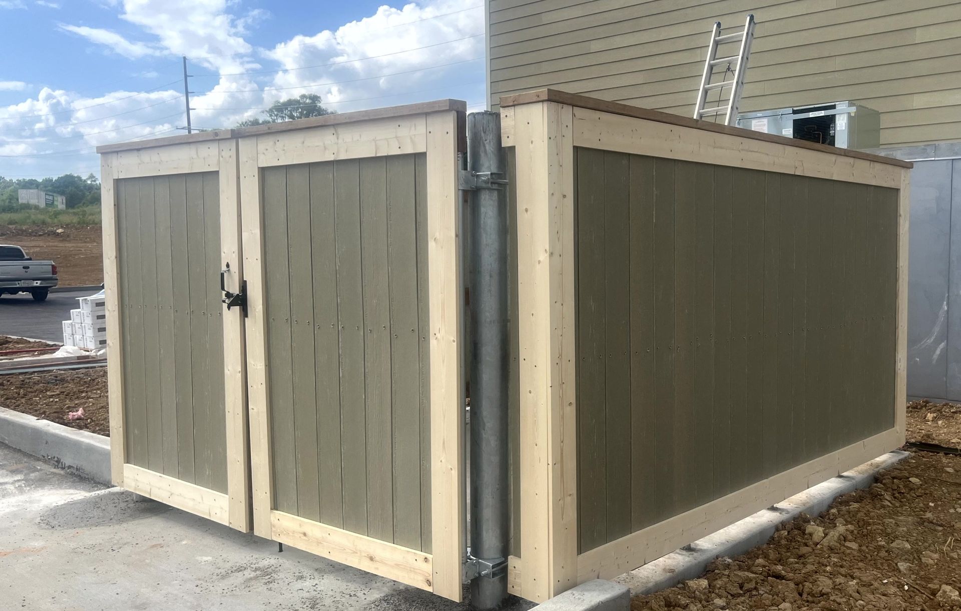 Commercial dumpster enclosure with solid privacy panels installed by Makic Fence and Deck