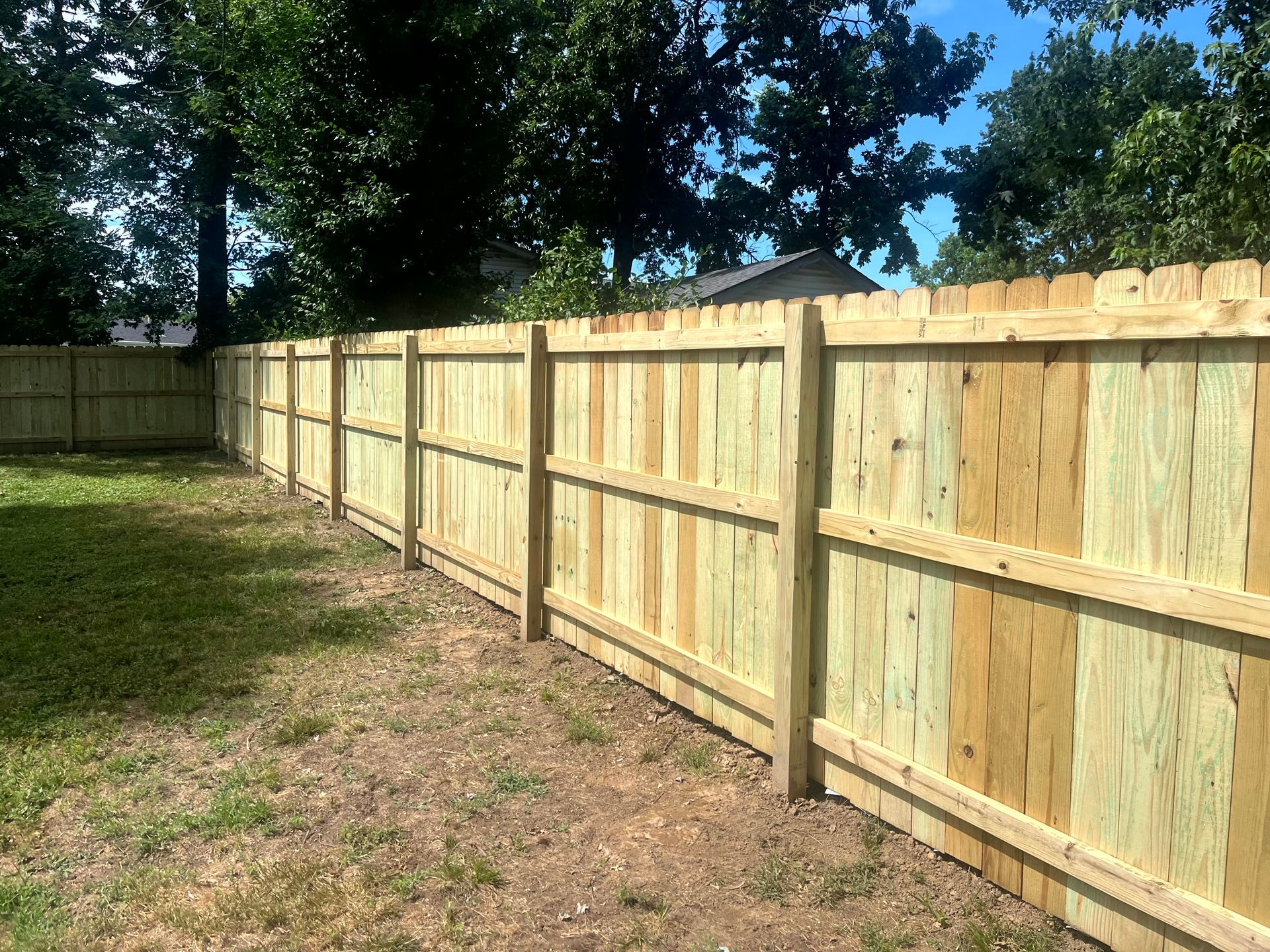 Treated wood fence installed along a residential side yard