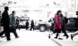 A group of people are walking across a busy city street.