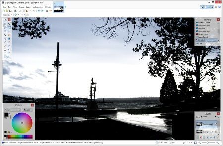 A computer screen running the Paint.net software shows a black and white photo of a river and trees
