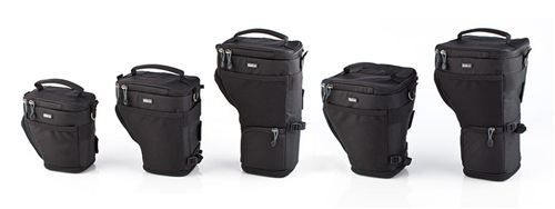 A row of black camera bags of different sizes are lined up on a white surface.