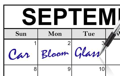 A pen is writing words into boxes on a calendar for the month of September