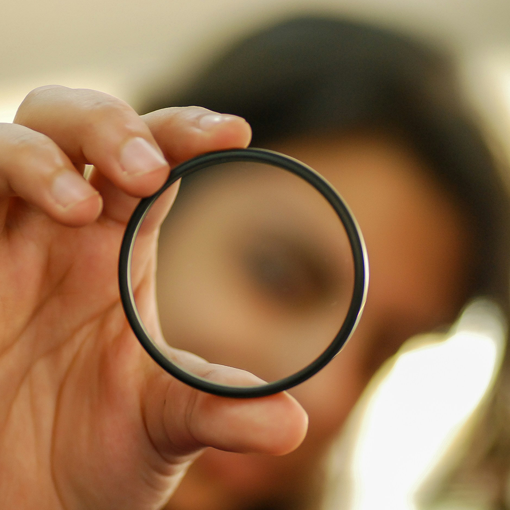 A person is holding a camera lens in their hand