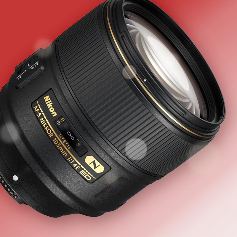 A close up of a nikon lens on a pink background