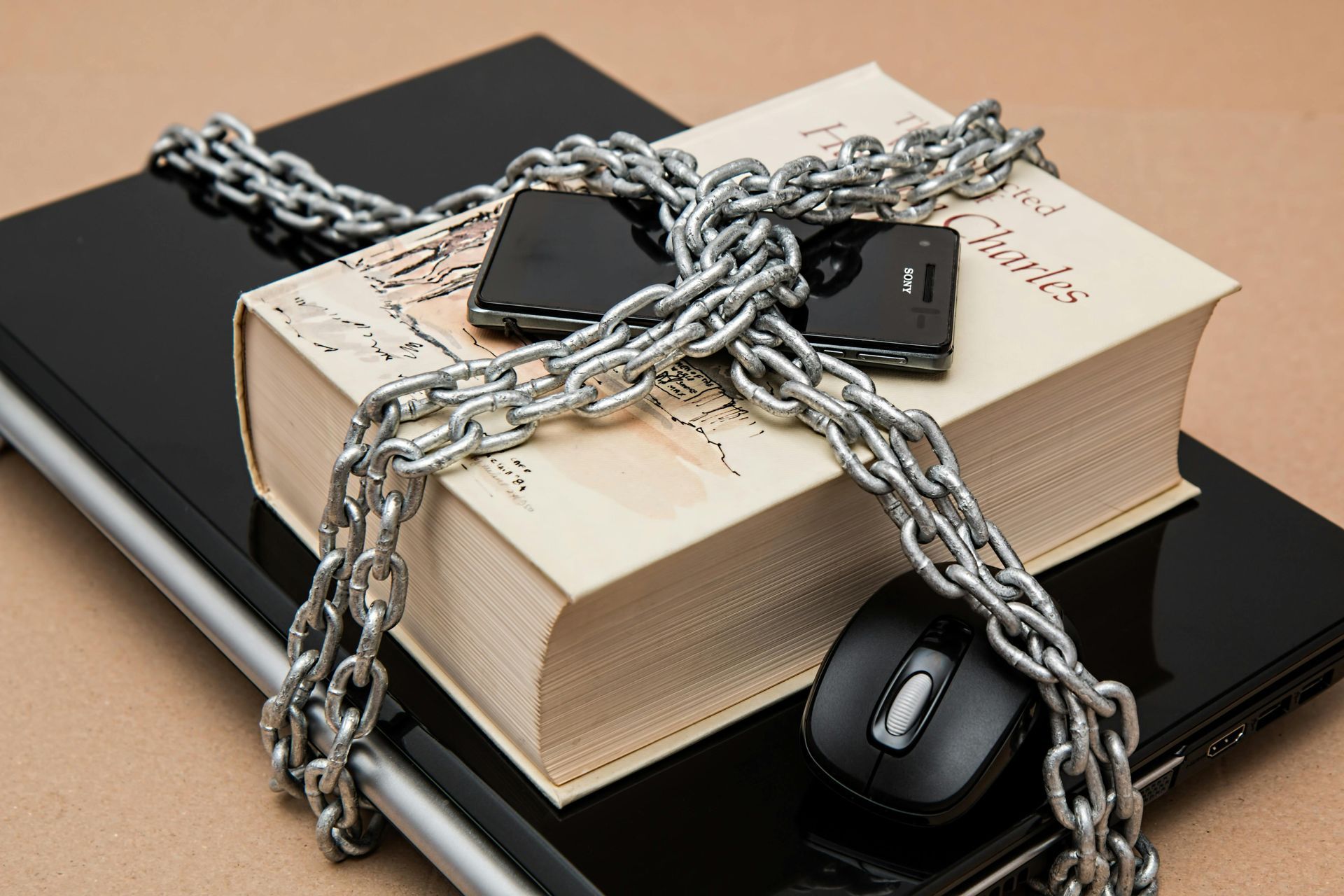A book is chained to a laptop and a mouse
