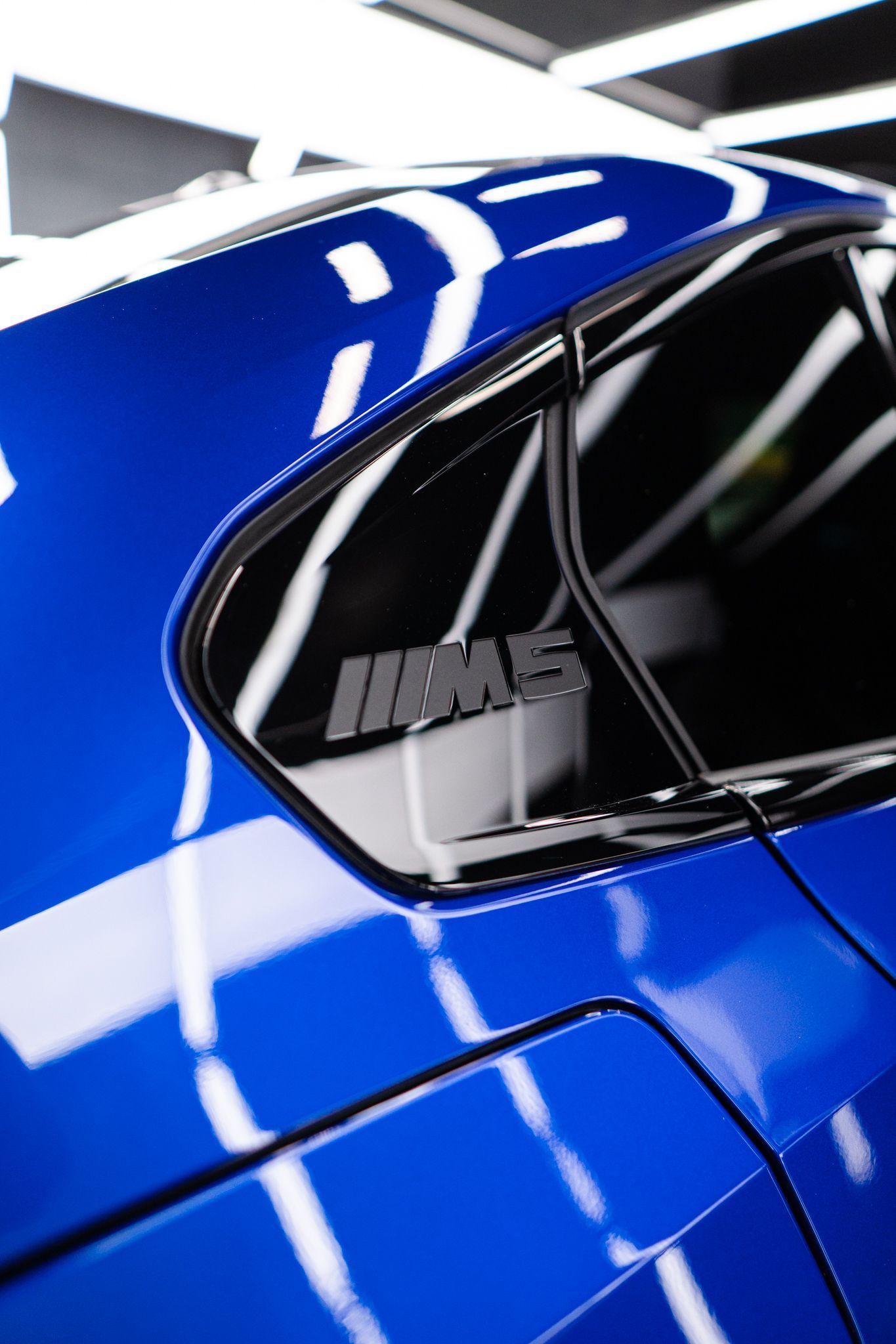 Blue BMW M5 with black tinted window and emblem.