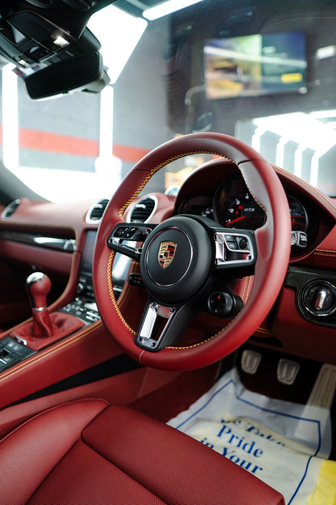 Red leather Porsche interior with a steering wheel and dashboard details.