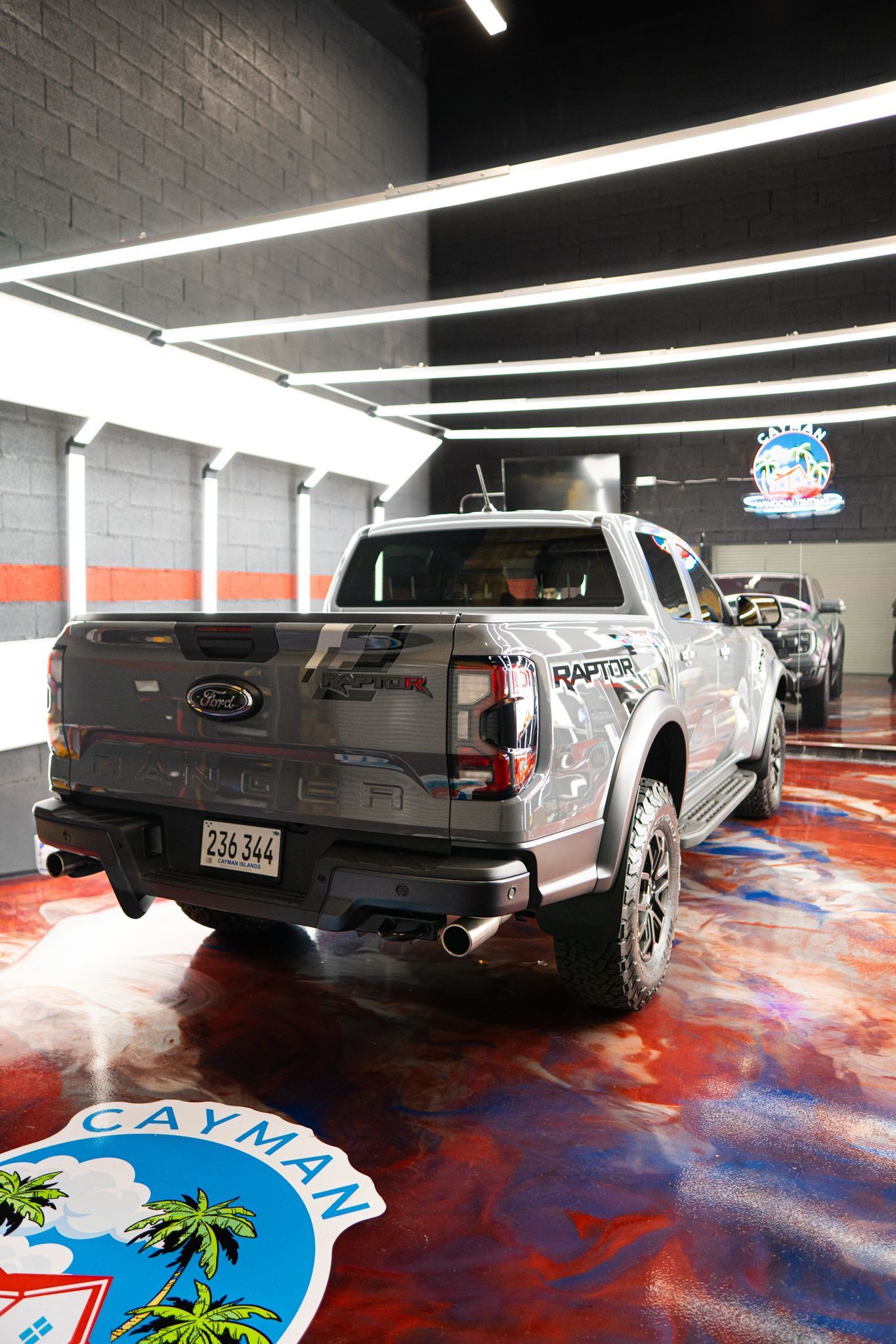 Gray Ford truck in a wash bay with Cayman Islands logo on the floor.