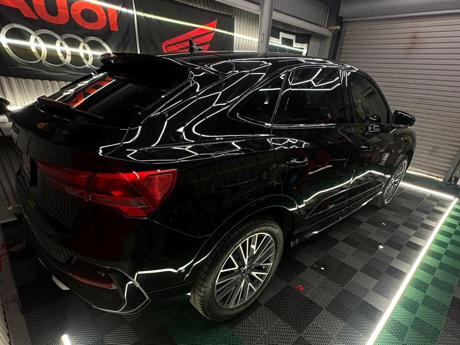 A black car is parked in a garage.