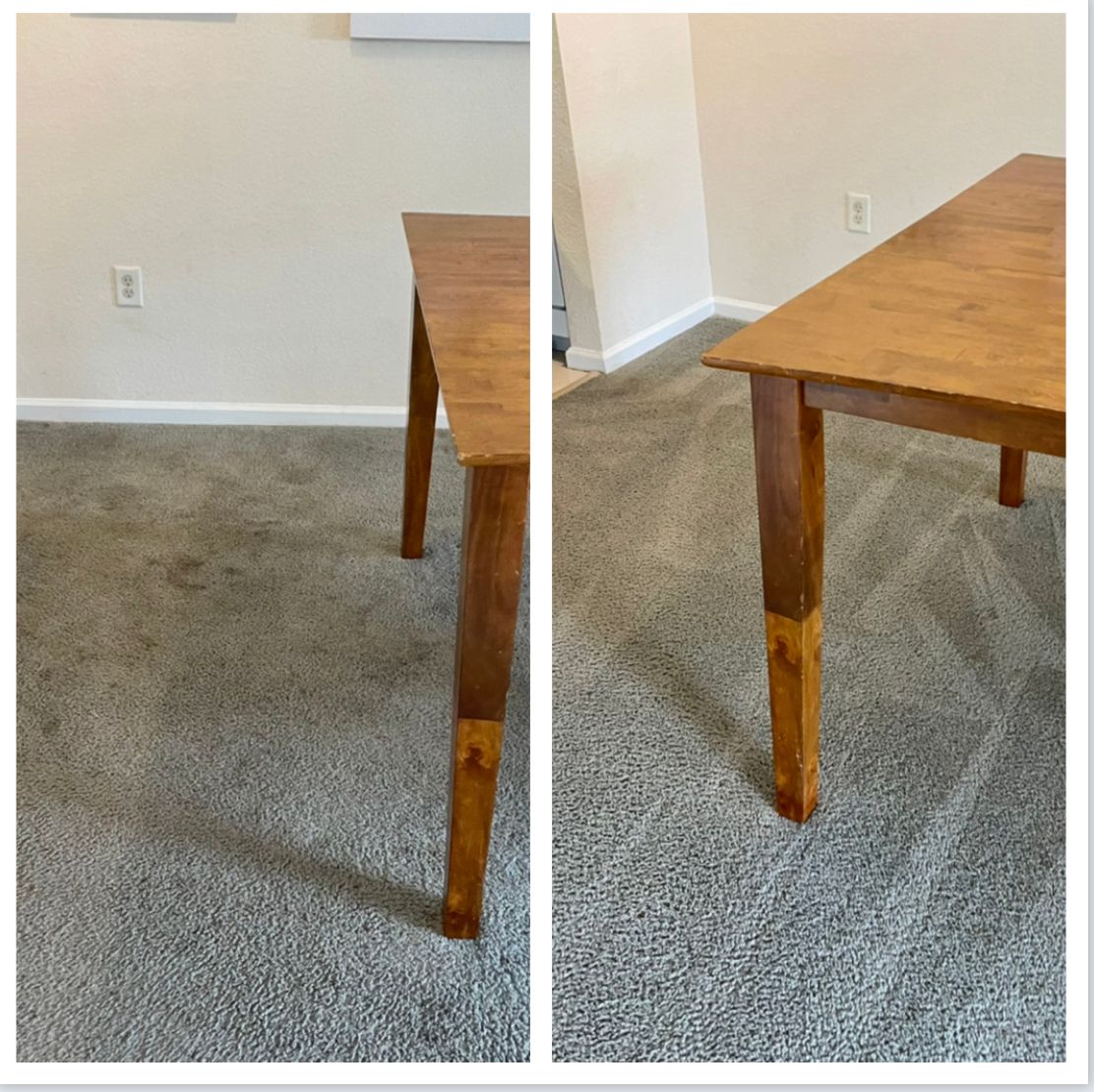A wooden table on gray carpet with a tan wall background.