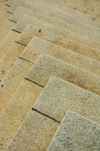Stone staircase, angled view, tan and gray tones, textured surface.