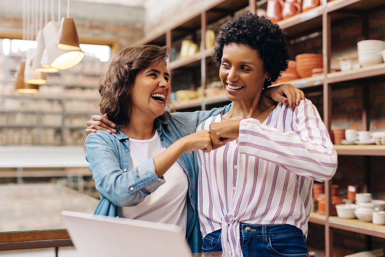 duas mulheres empreendedoras comemorando que conseguiram manter um capital de giro qualitativo em caixa