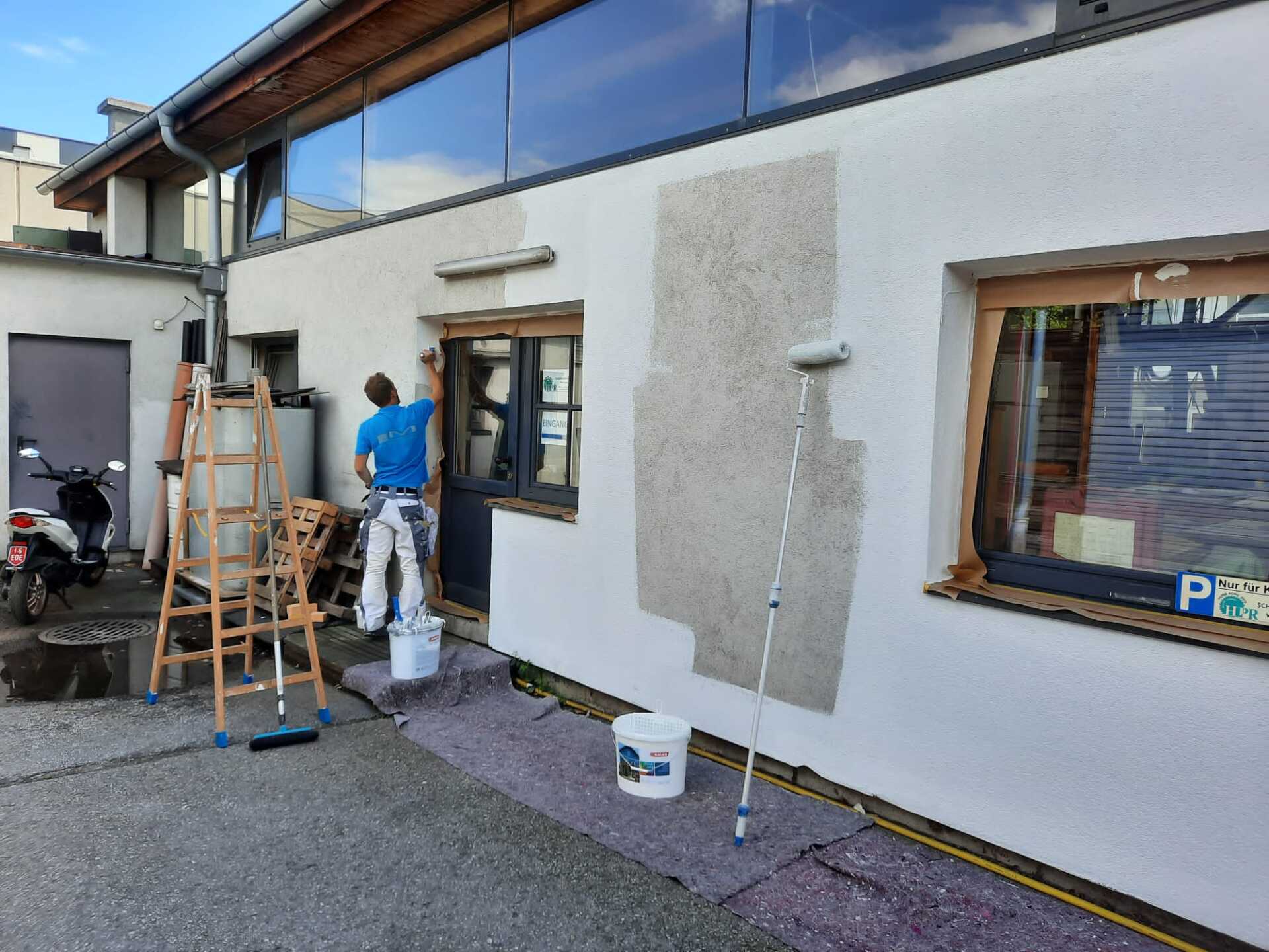 eine Hausmauer wird bemalt