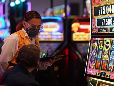 Una mujer que lleva una máscara está atendiendo a un hombre en un casino.
