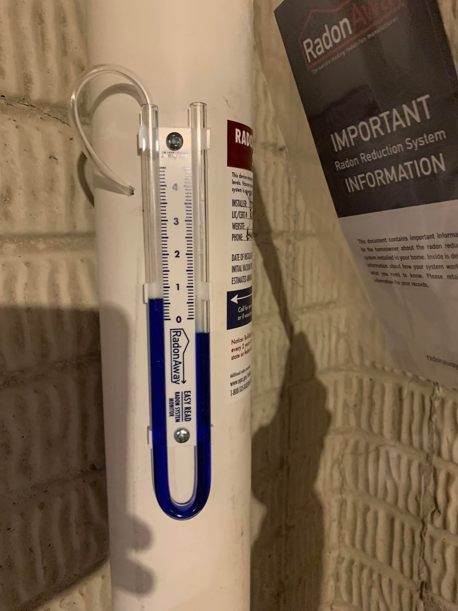 A thermometer is attached to a white tube with a blue handle.