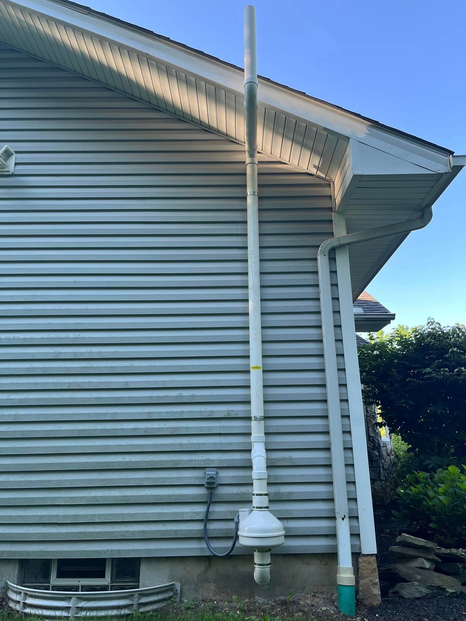 A white house with a white gutter on the side of it.