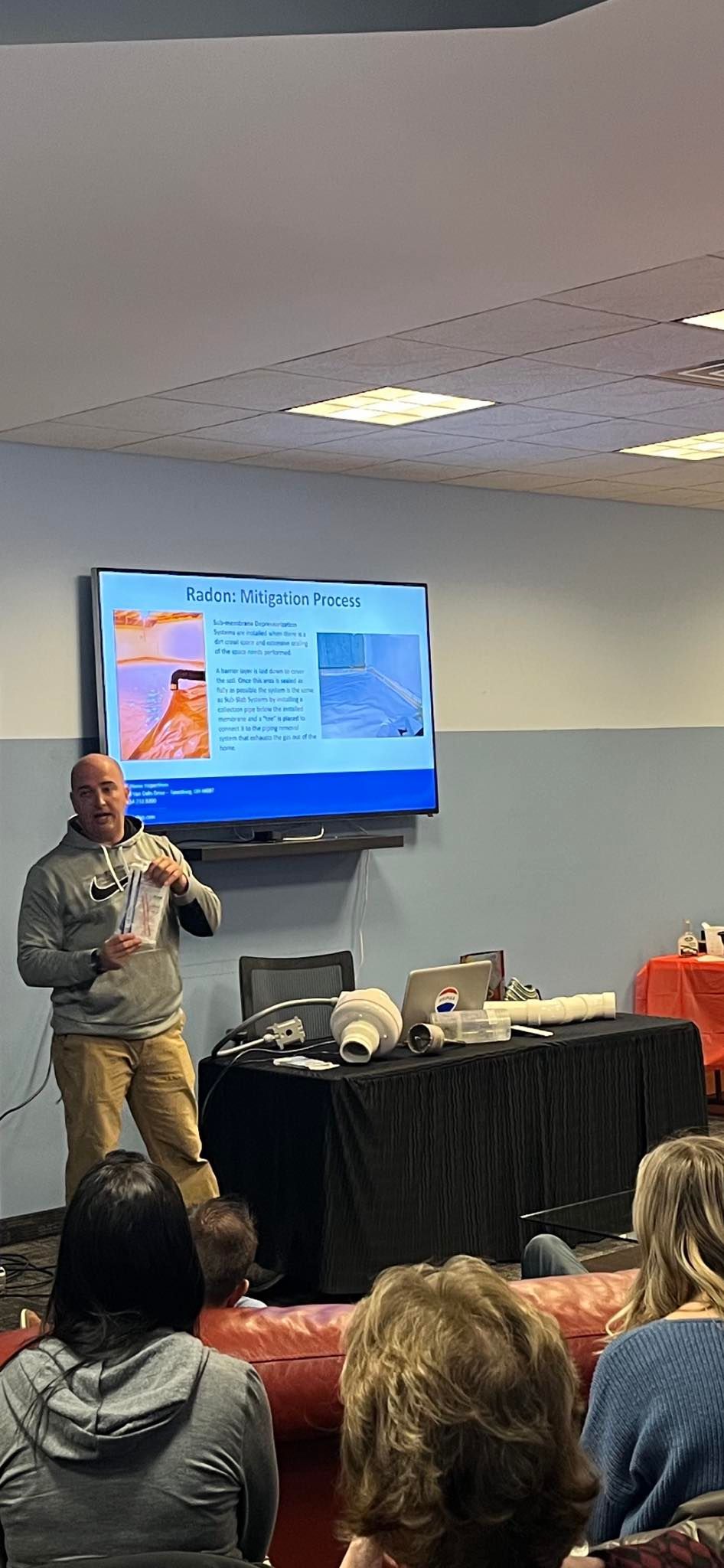A man is giving a presentation to a group of people in a room.