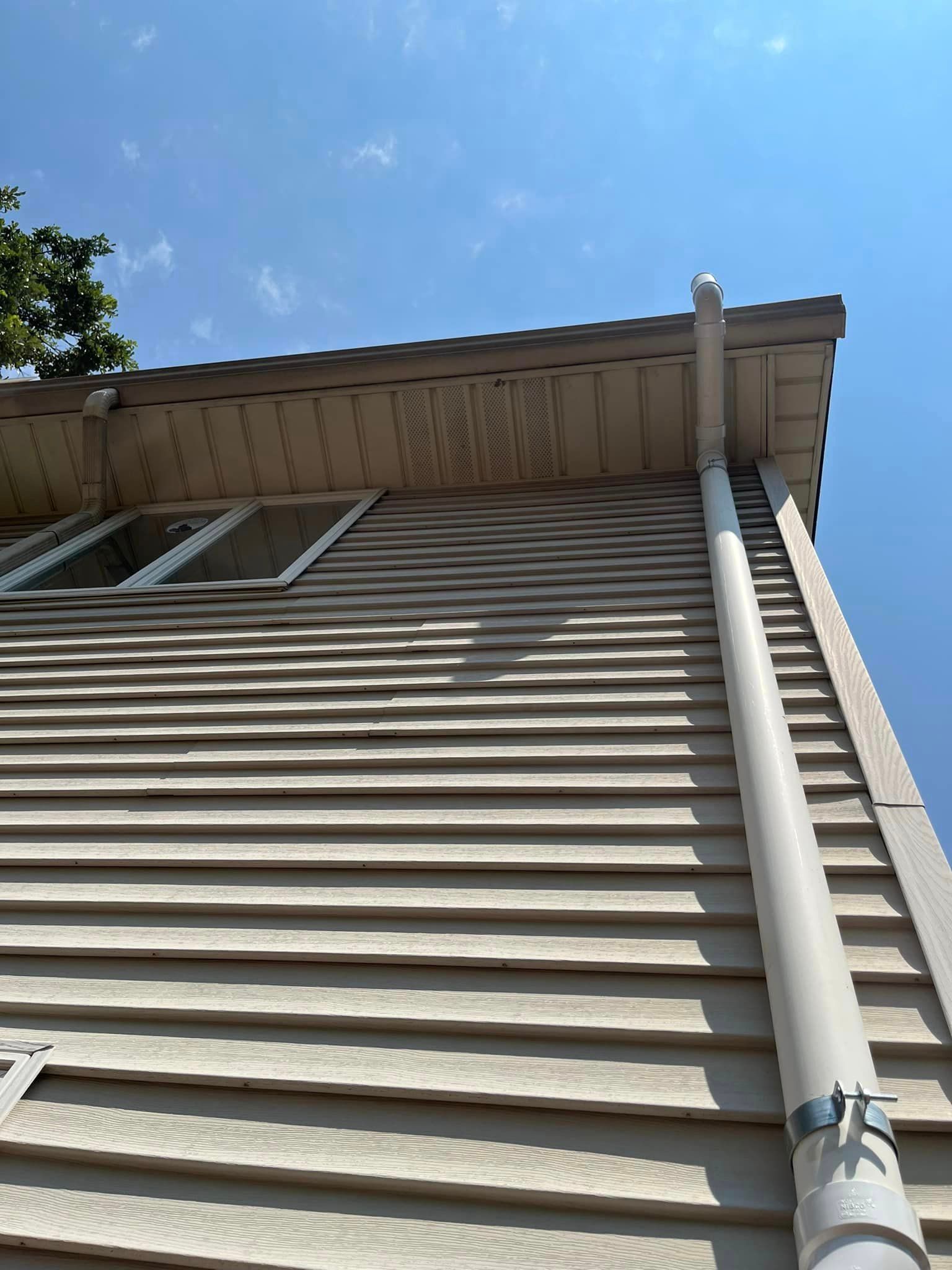 A house with a gutter on the side of it and a roof.