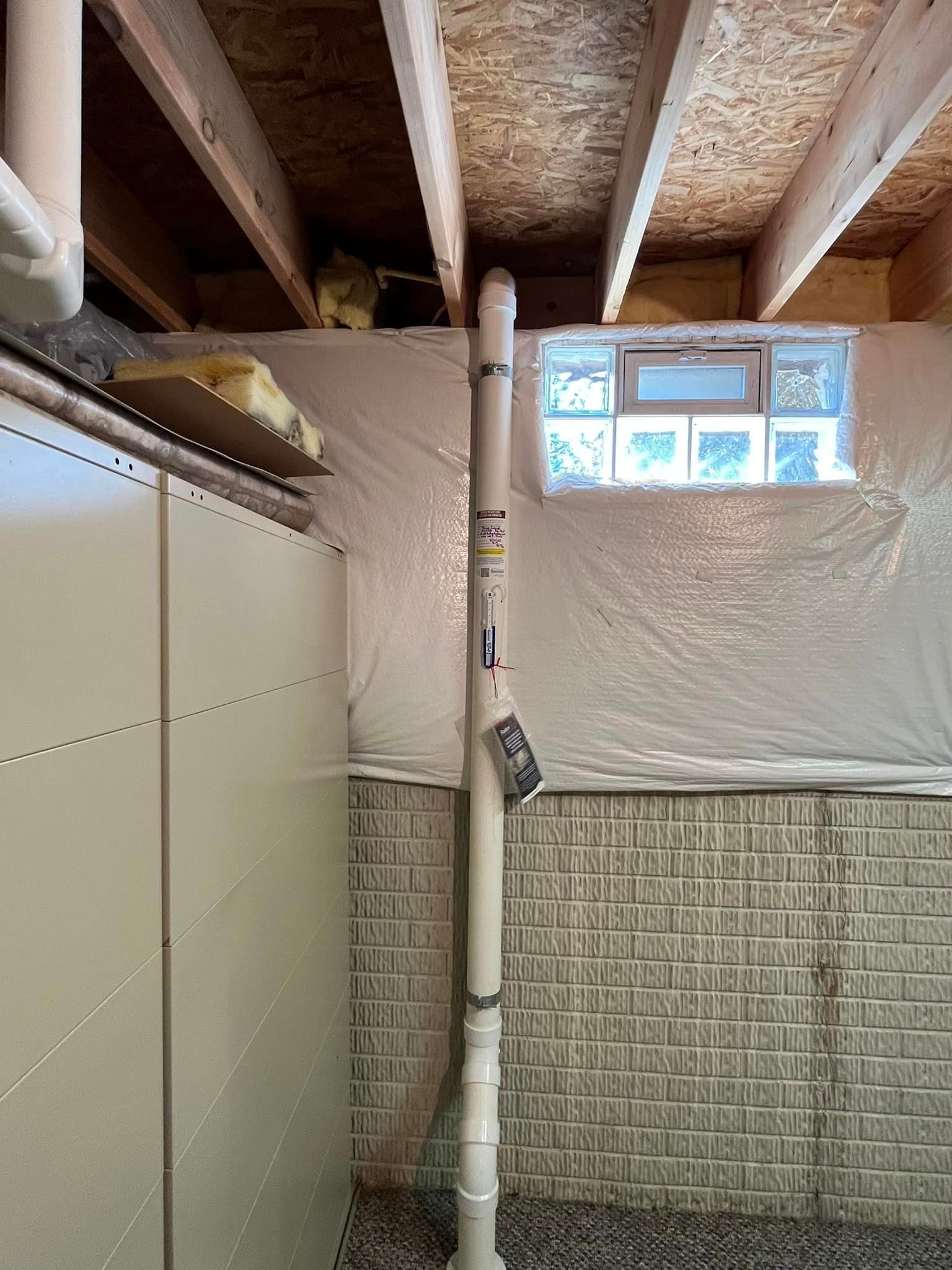 A basement under construction with a brick wall and a window.