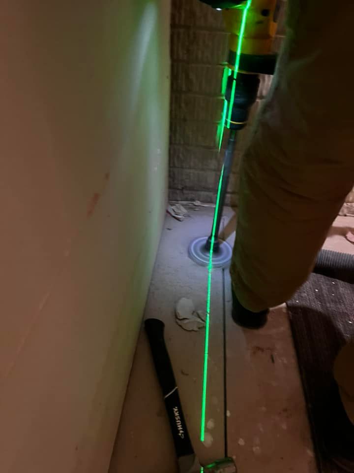 A person is using a laser to measure a hole in a wall.