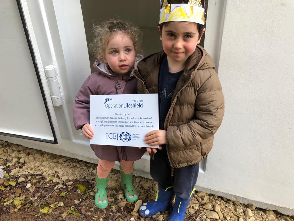 A boy and a girl are standing next to each other holding a certificate.