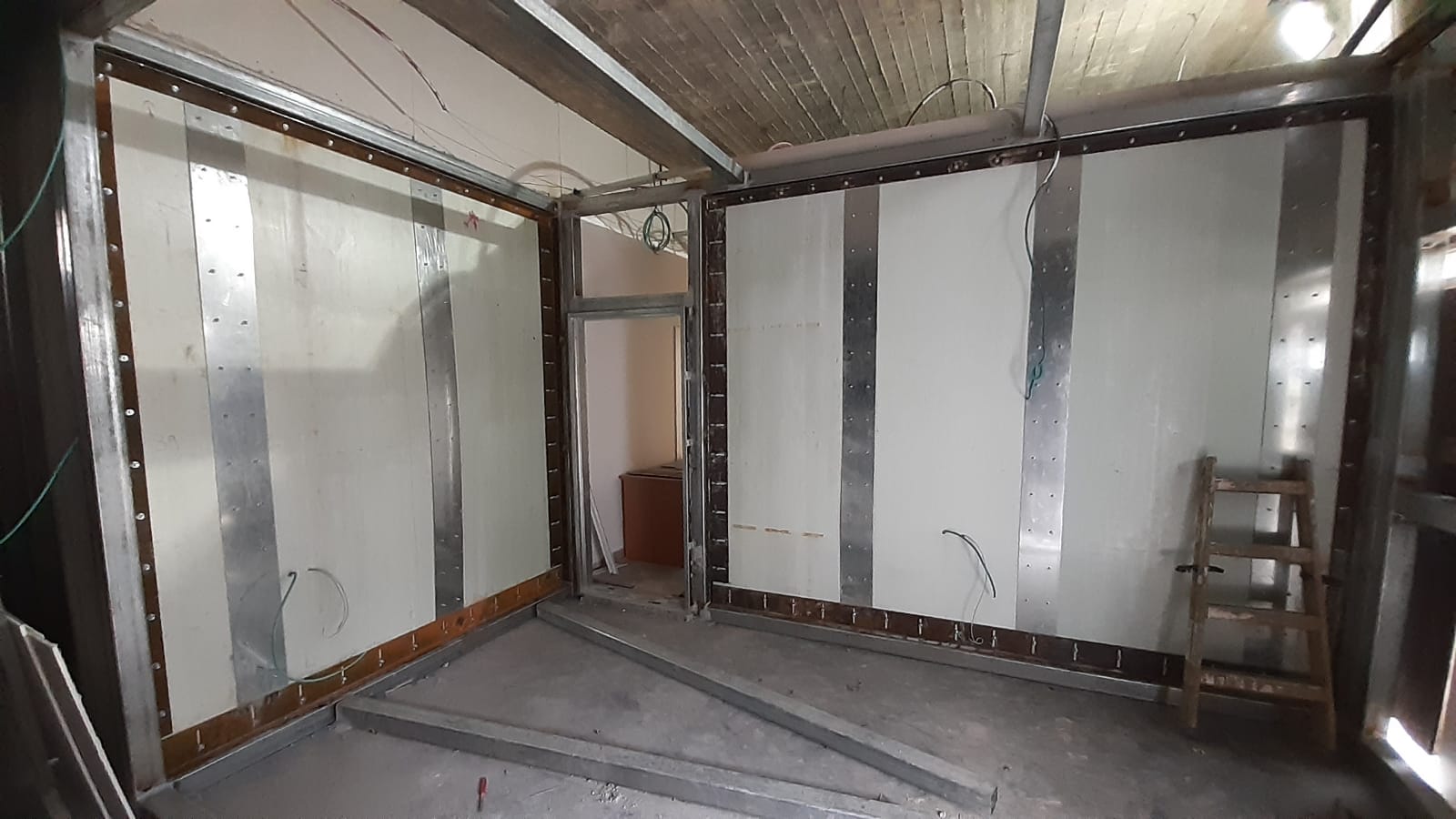 A room with white walls and a wooden ladder in it.