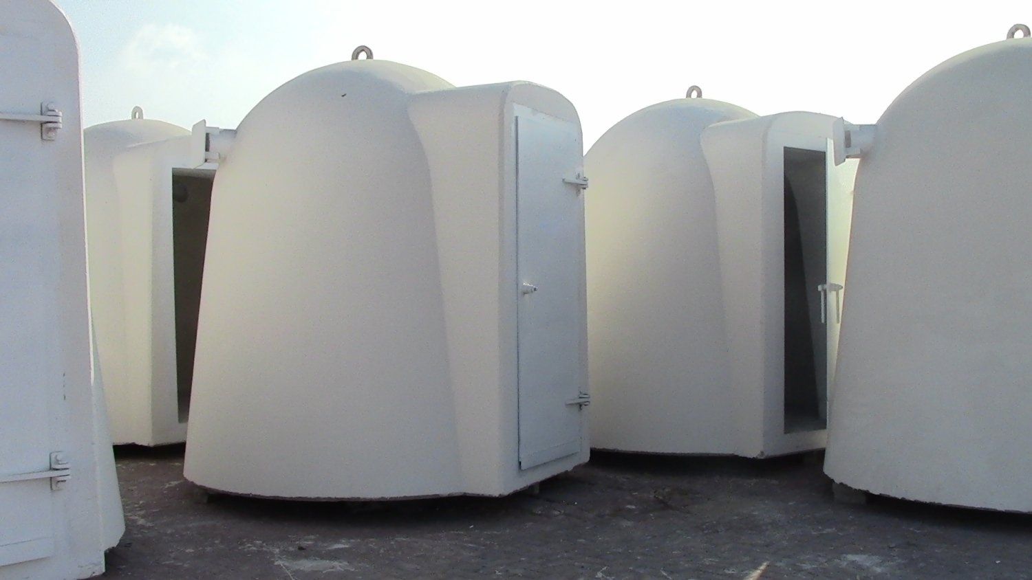 A row of white containers are lined up in a row